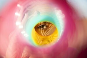 Künstlerische Nahaufnahme eines Auges, das durch einen bunten, kreisförmigen Effekt blickt – Sinnbild für Fokus, Wahrnehmung und neue Perspektiven.